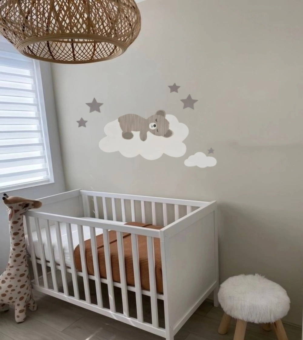 Behang muursticker beige neutrale babykamer met een teddybeer op wolk en sterren.